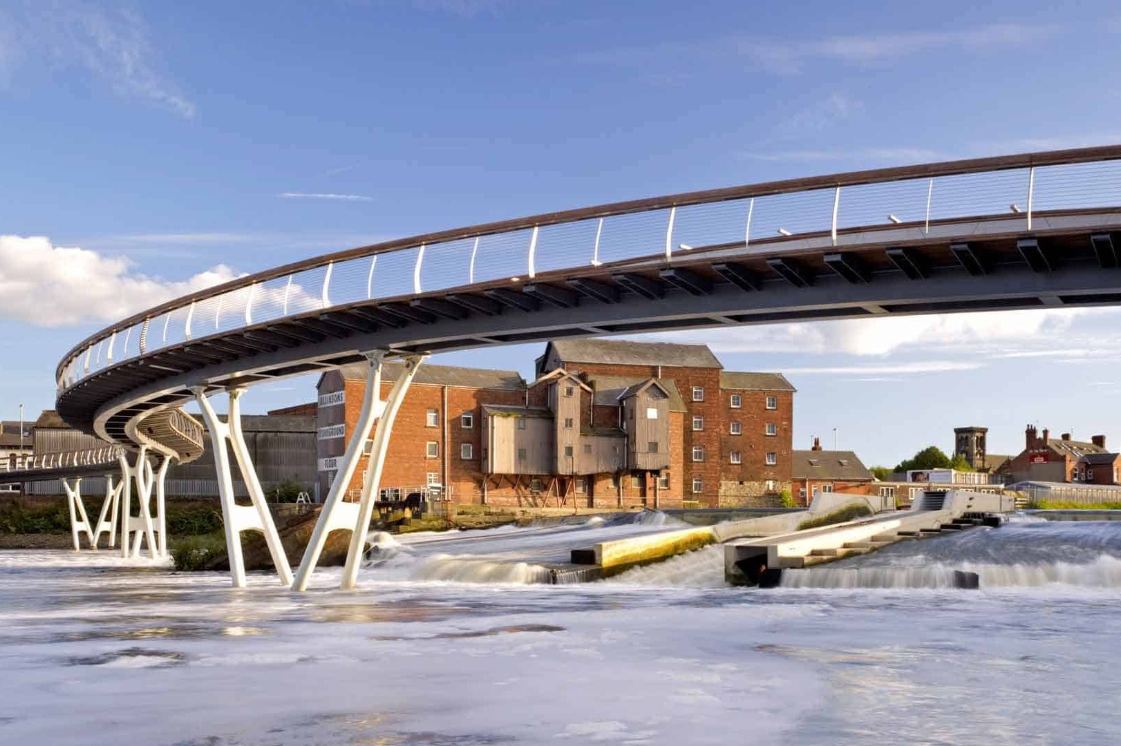 a bridge over the River Aire with Queen's Mill in the background