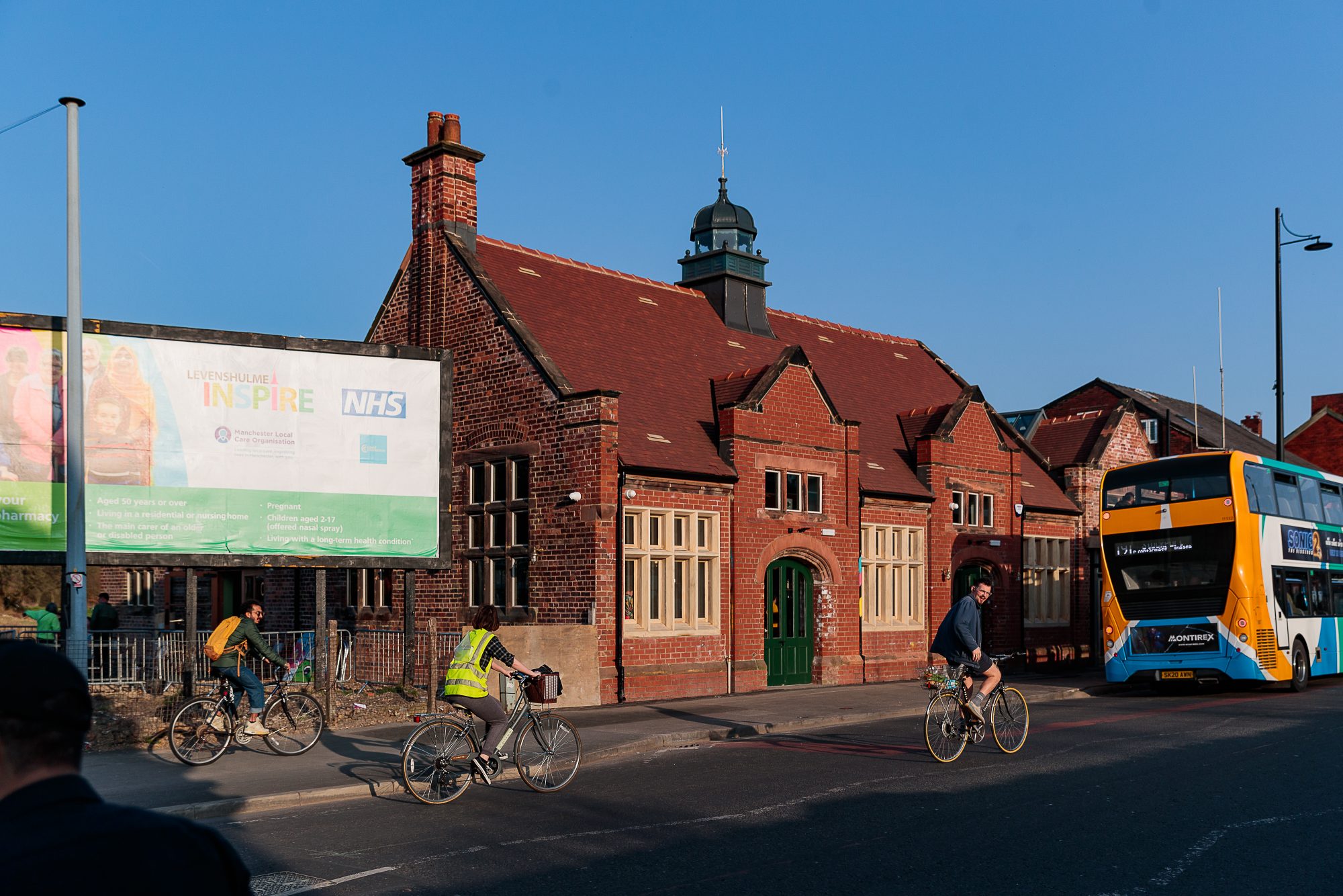 Station South CIC, a Victorian building on a high street with two cyclists outside
