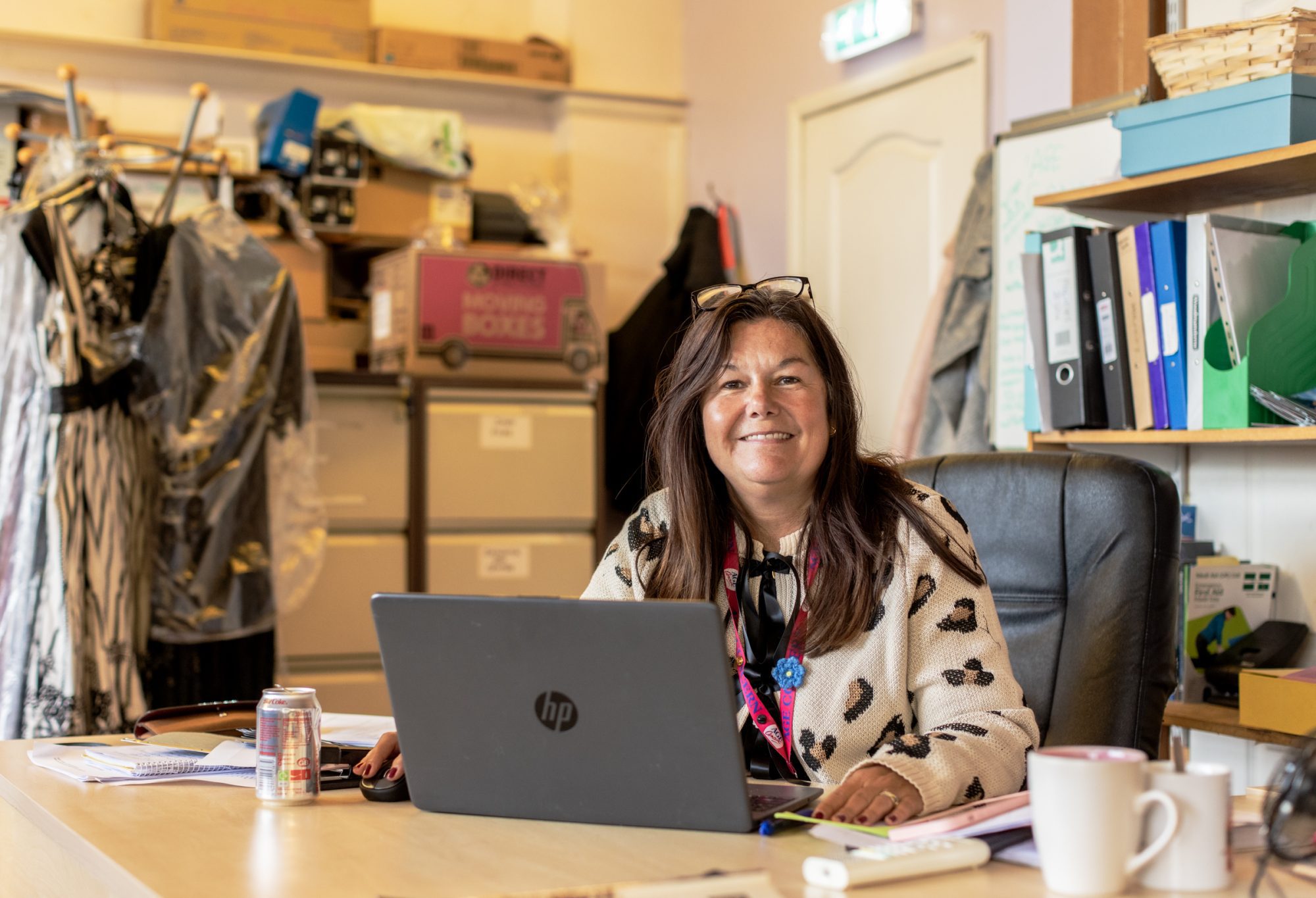person sitting at a desk with a laptop smiling