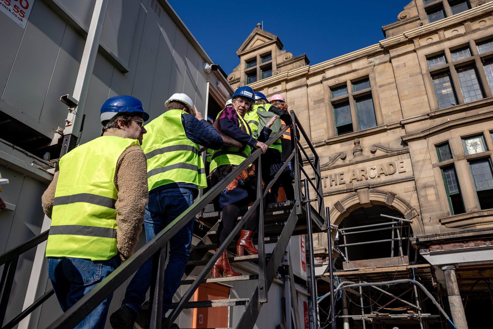 people in high vis walking up steps