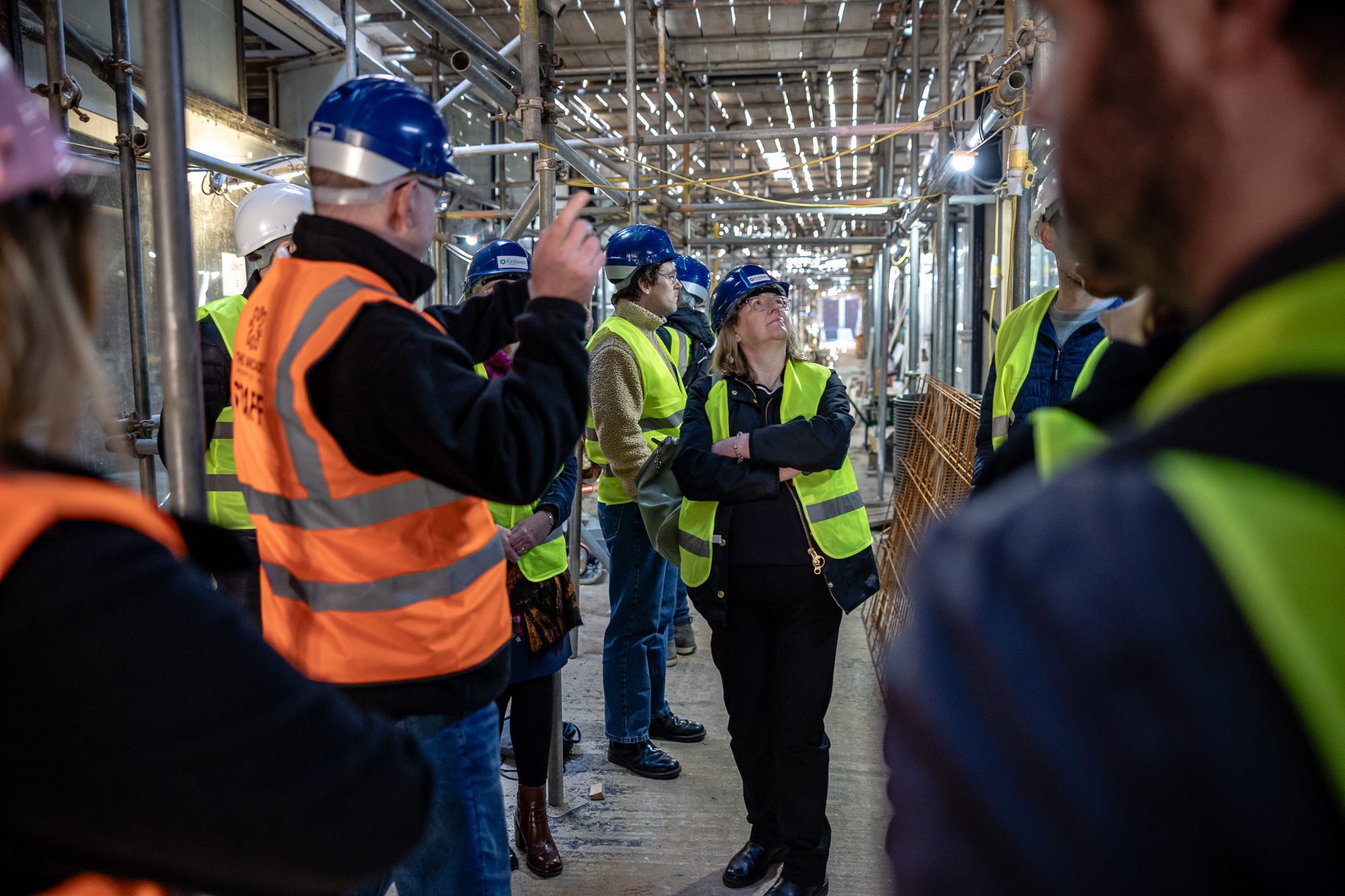people wearing high vis and helmets in a building site inside an arcade 